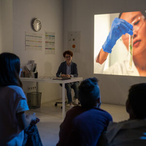 Youthful schoolkids watching video about scientific experiment at lesson